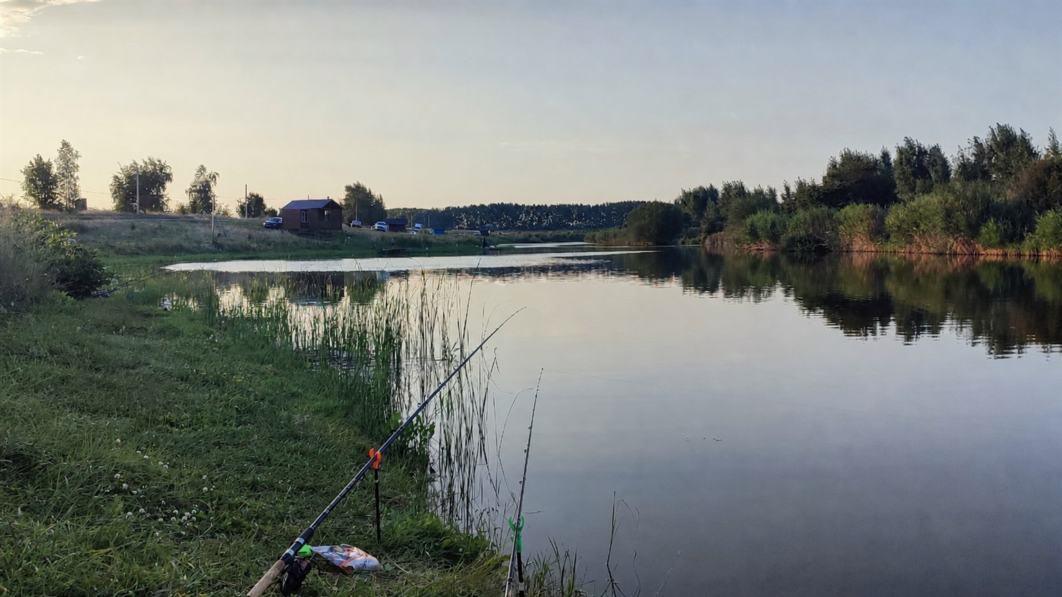 Правдинские пруды вечером, рыболовные удочки на берегу